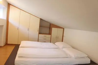 two beds in a room with white cabinets at Soliman in Bressanone