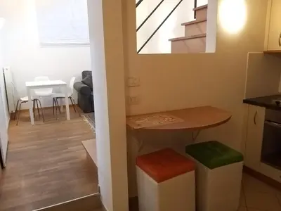 a kitchen and living room with a table and stool at Soliman in Bressanone