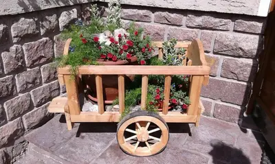 a wooden cart filled with plants and flowers at Hotel De Fronz in Soraga