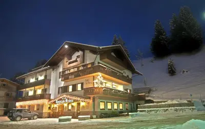 a large building with christmas lights in front of it at Hotel De Fronz in Soraga