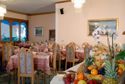 a dining room with tables and chairs with fruits on them at Hotel Sass Maor in Fiera di Primiero