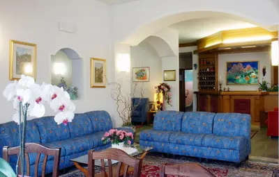 a living room with a blue couch and a table at Hotel Sass Maor in Fiera di Primiero