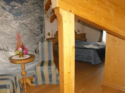 a bedroom with a bunk bed and a table with a chair at Hotel Sass Maor in Fiera di Primiero