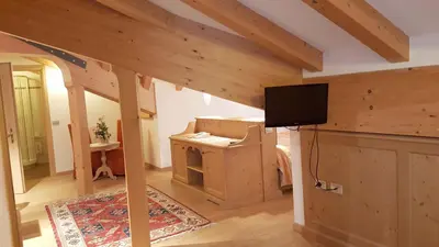 a living room with a tv on a wall at Hotel Sass Maor in Fiera di Primiero