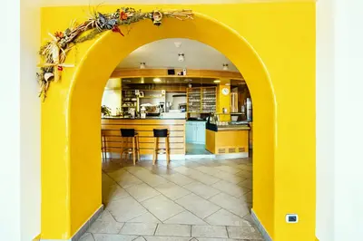 an archway in a kitchen with a yellow wall at Gasthof Teiser Stern in Funes