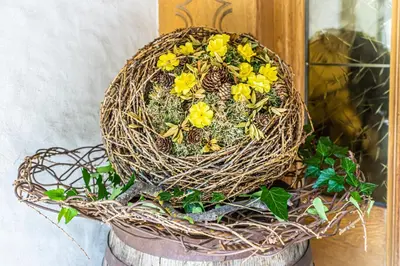 a basket with yellow flowers in it sitting on a barrel at Gasthof Teiser Stern in Funes