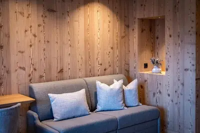a bedroom with a large bed with a wooden wall at Hotel Dosses in Tires