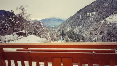 a view of a snow covered mountain from a bench at Mesnerhof in Lauregno