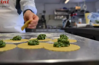 a chef preparing food on a counter in a kitchen at Angerburg Blumenhotel in Appiano sulla Strada del Vino