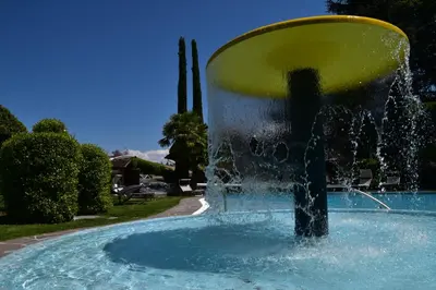 a water fountain in a pool of water at Angerburg Blumenhotel in Appiano sulla Strada del Vino