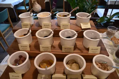 a display of bowls of food on a wooden table at Angerburg Blumenhotel in Appiano sulla Strada del Vino