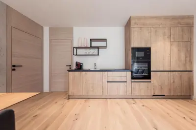 a kitchen with wooden cabinets and a counter top at SOFTALPIN Garden Suites in Appiano sulla Strada del Vino