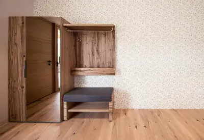 a room with a bench in a room with a wall at SOFTALPIN Garden Suites in Appiano sulla Strada del Vino