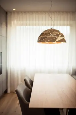 a dining room table with a chair and a light at SOFTALPIN Garden Suites in Appiano sulla Strada del Vino