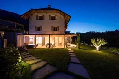 a large white house with a grass yard at SOFTALPIN Garden Suites in Appiano sulla Strada del Vino