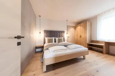 a bedroom with a large bed in a room at SOFTALPIN Garden Suites in Appiano sulla Strada del Vino
