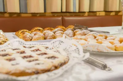 a table topped with trays of pastries and pies at Residence Pitzinger in Falzes