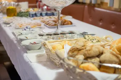 a table with a buffet of pastries and wine glasses at Residence Pitzinger in Falzes