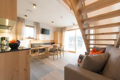 a kitchen and living room with a couch and a table at Residence Pitzinger in Falzes