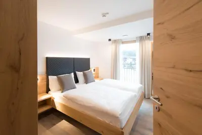 a bedroom with a white bed and a window at Residence Pitzinger in Falzes