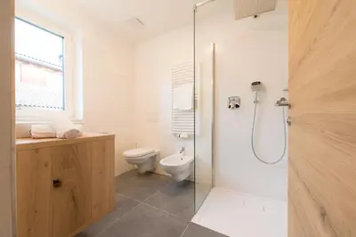 a bathroom with a toilet and a glass shower at Residence Pitzinger in Falzes