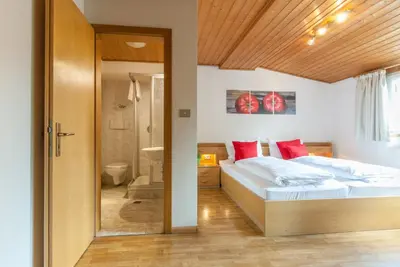 a bedroom with a bed and a bathroom at Gasthof Hanni in Merano