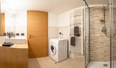 a bathroom with a washing machine and a sink at Appartamento Ciasa Ciaslir in Vigo di Fassa