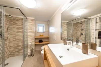 a bathroom with a sink and a shower at Appartamento Ciasa Ciaslir in Vigo di Fassa