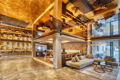 a lobby of a building with couches and a bar at Hotel Avelina in Avelengo