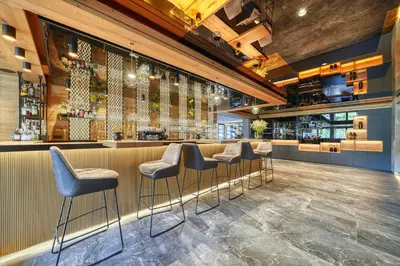 a bar in a restaurant with stools at Hotel Avelina in Avelengo