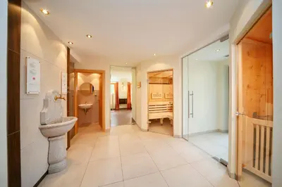 a hallway with a bathroom with a toilet and a sink at Hotel Avelina in Avelengo