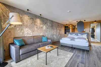 a living room with a couch and a bed at Hotel Avelina in Avelengo