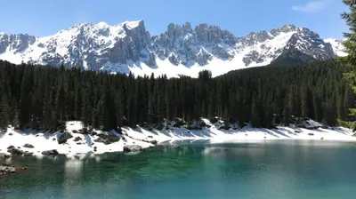 a body of water with snow capped mountains in the background at Residence Chris Appart in Carezza al Lago