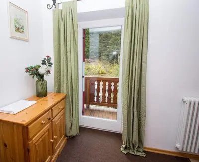 a room with a wooden dresser and a window at Residence Chris Appart in Carezza al Lago