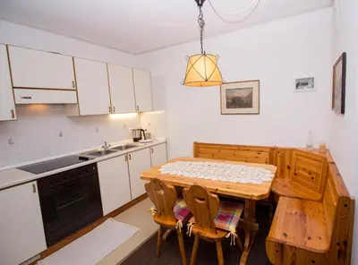 a small kitchen with a wooden table and chairs at Residence Chris Appart in Carezza al Lago