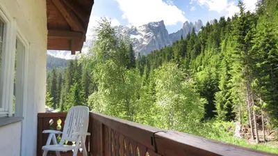 a balcony with two chairs and a view of the mountains at Residence Chris Appart in Carezza al Lago