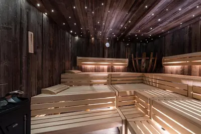 an empty sauna with wooden walls and wooden floors at Hotel - Appartements Schmied Hans in Schenna