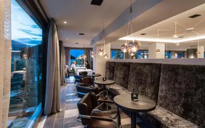 a restaurant with tables and chairs and a large window at Hotel - Appartements Schmied Hans in Schenna