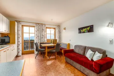 a living room with a red couch and a table at Nussbaumerhof in Bressanone