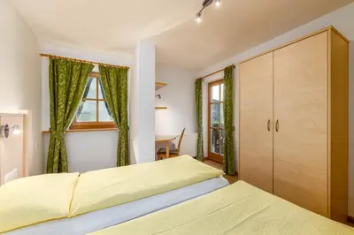 a bedroom with two beds and a window at Nussbaumerhof in Bressanone