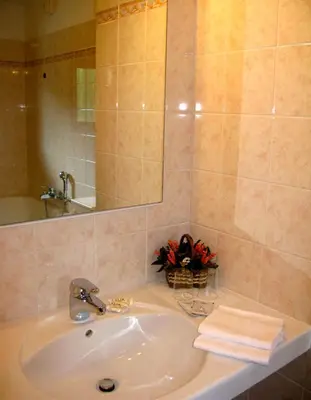 a bathroom sink with a mirror and a towel at Hotel Villa Nevada in Cortina dʼAmpezzo