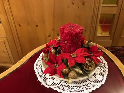 a plate with red flowers and ornaments on a table at Hotel Villa Nevada in Cortina dʼAmpezzo