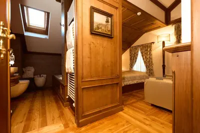 a bedroom with a large bed with a yellow headboard at Ambra Cortina Luxury&Fashion Hotel in Cortina dʼAmpezzo