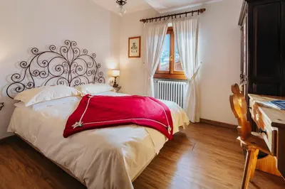 a bedroom with a bed with a red blanket on it at Hotel Panda Cortina- ricarica auto elettriche in Cortina dʼAmpezzo