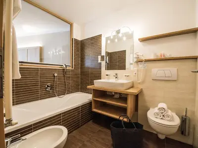 a bathroom with a sink and a tub and a toilet at Apartment Sella in Siusi
