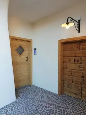 a room with two wooden doors and a wall at Casa Lassù in Carano