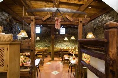 a restaurant with wooden ceilings and tables and chairs at Hotel Löwenwirt in Cermes