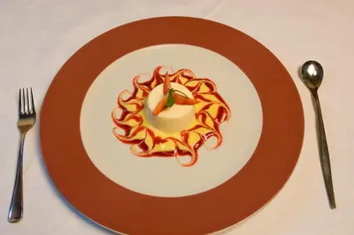 a plate with a dessert with a candle on it at Hotel Löwenwirt in Cermes