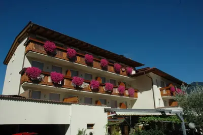 a building with pink flowers on the balconies at Hotel Löwenwirt in Cermes
