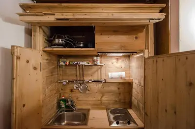 a tiny kitchen with a sink and a microwave at La Roncolina in Cortina dʼAmpezzo